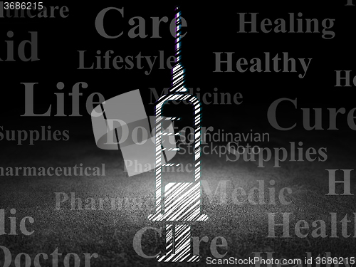 Image of Medicine concept: Syringe in grunge dark room