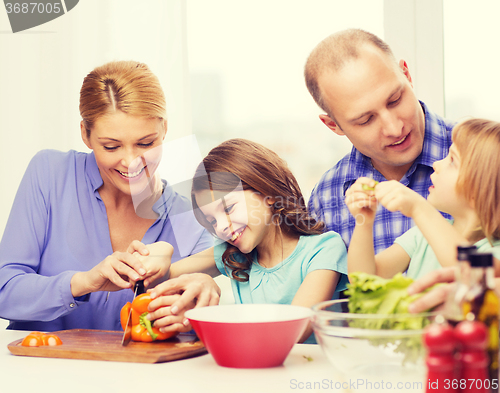 Image of happy family with two kids making dinner at home