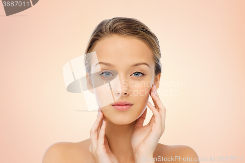 Image of young woman touching her face