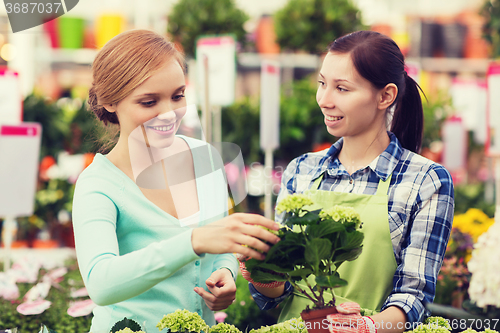 Image of happy women choosing flowers in greenhouse