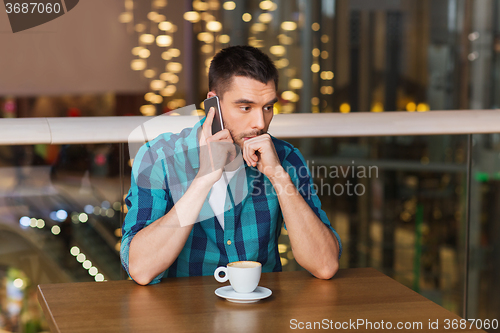 Image of man with smartphone and coffee at restaurant