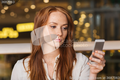 Image of woman with smartphone and coffee at restaurant