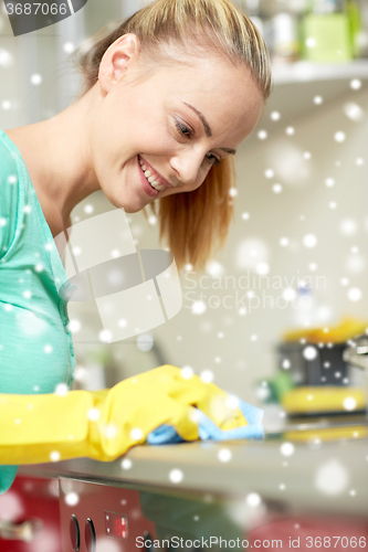 Image of happy woman cleaning cooker at home kitchen