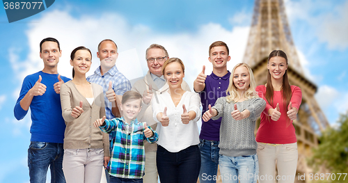 Image of smiling people showing thumbs up over eiffel tower