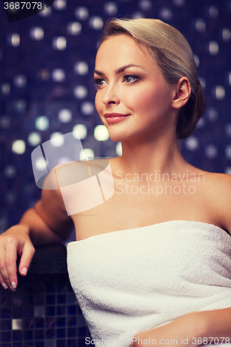 Image of beautiful young woman sitting in bath towel