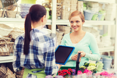 Image of happy women with tablet pc at flower shop