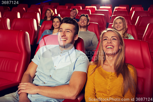 Image of happy friends watching movie in theater