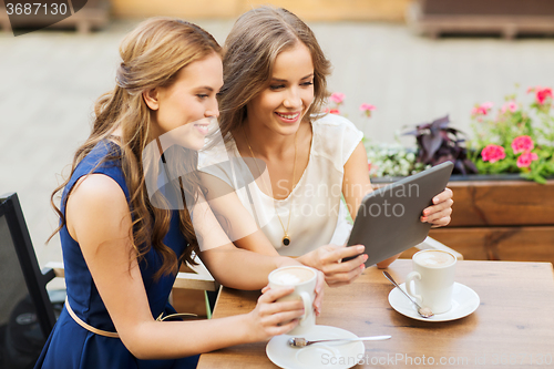 Image of young women with tablet pc and coffee at cafe