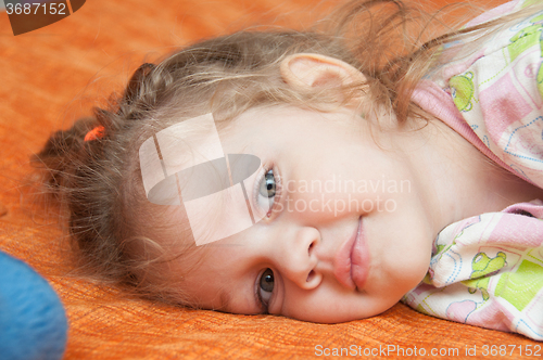 Image of Portrait of cheerful three-year girl lying on the couch