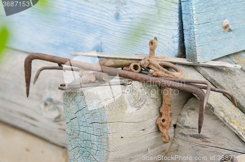 Image of Pile of old tools and pieces of iron lying on the wooden frame of the old house