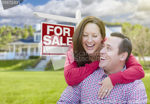 Image of Happy Couple In Front of For Sale Sign and House