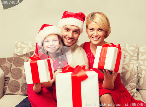 Image of smiling family giving many gift boxes