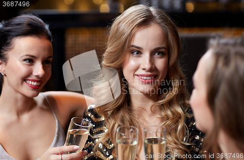 Image of happy women with champagne glasses at night club