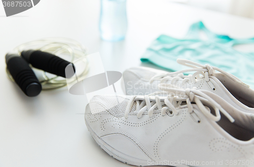 Image of close up of sportswear, skipping rope and bottle