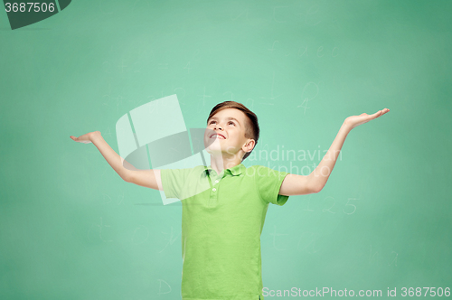 Image of happy school boy in polo t-shirt raising hands up