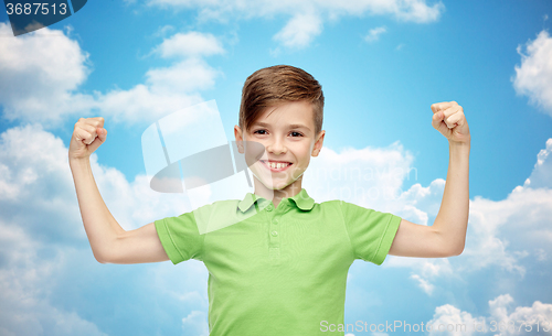 Image of happy boy in polo t-shirt showing strong fists