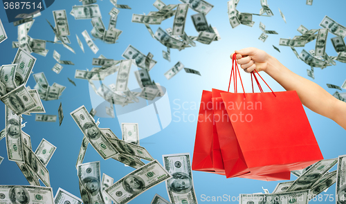 Image of close up of hand holding red shopping bags