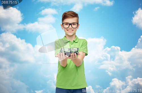 Image of happy boy in green polo t-shirt holding eyeglasses