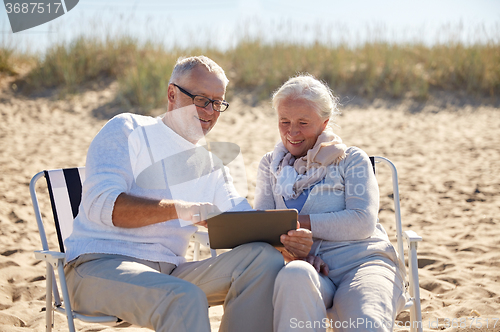 Image of happy senior couple with tablet pc on summer beach