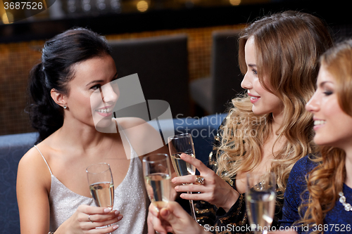 Image of happy women with champagne glasses at night club