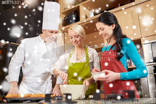 Image of happy women and chef cook baking in kitchen