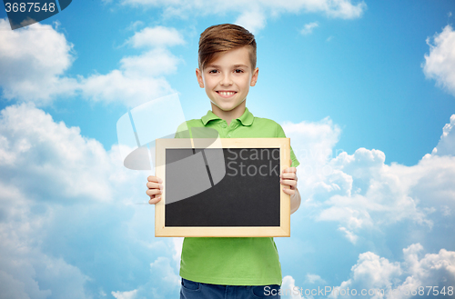 Image of happy boy in t-shirt holding blank chalk board