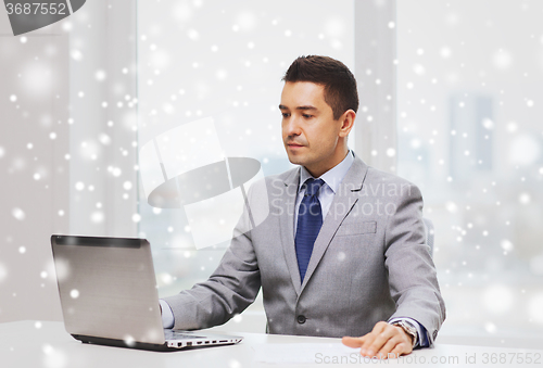 Image of businessman working with laptop in office