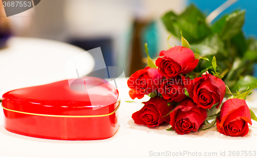 Image of close up of chocolate box and red rose flowers