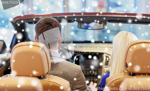 Image of couple sitting in cabrio car at auto show