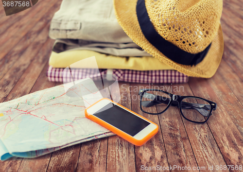 Image of close up of summer clothes and travel map on floor