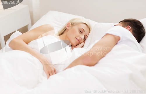 Image of happy couple sleeping in bed at home