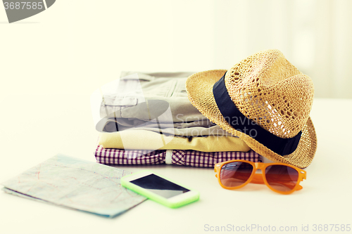 Image of close up of summer clothes and travel map on table