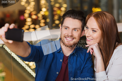 Image of couple taking selfie by smartphone at restaurant