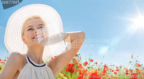 Image of smiling young woman in straw hat on poppy field