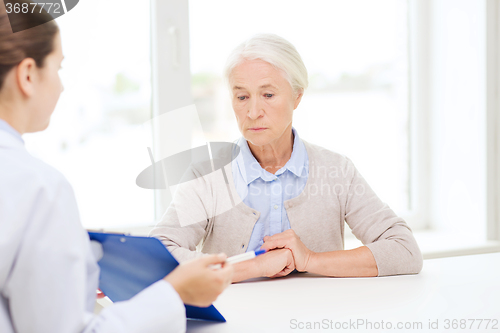 Image of doctor with clipboard and senior woman at hospital