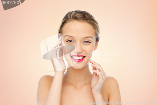 Image of smiling young woman with pink lipstick on lips