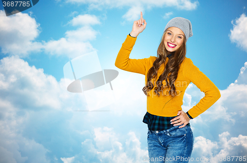 Image of happy young woman or teen girl pointing finger up