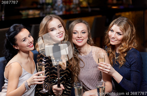 Image of women with smartphone taking selfie at night club