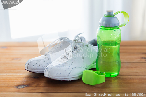 Image of close up of sneakers, bracelet and water bottle