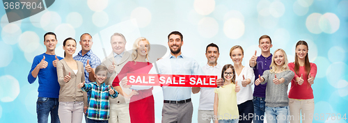 Image of happy people with red sale sign showing thumbs up