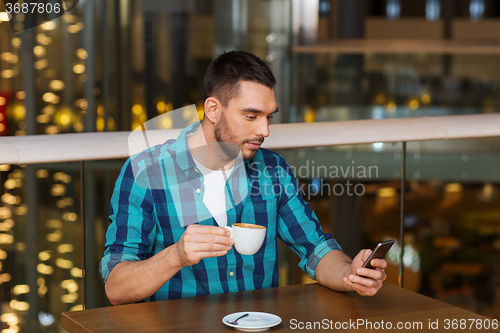 Image of man with smartphone and coffee at restaurant