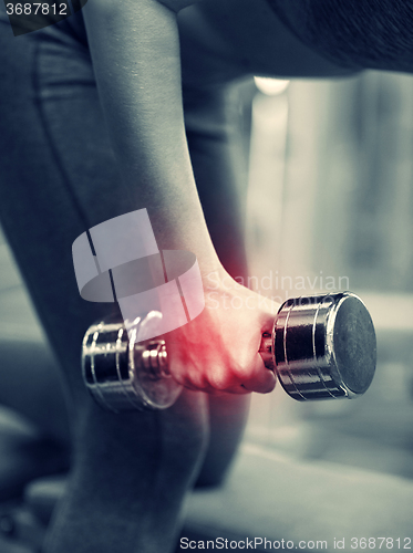 Image of close up of woman with dumbbell exercising in gym