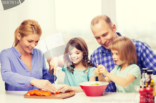 Image of happy family with two kids making dinner at home