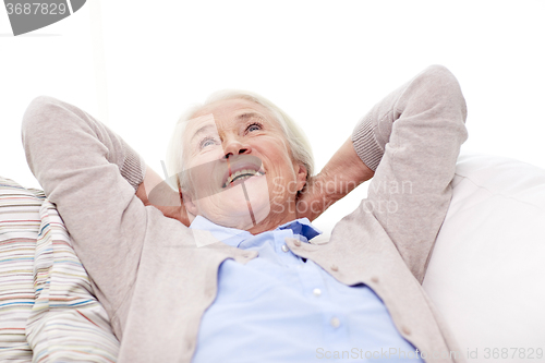 Image of happy senior woman resting on sofa at home