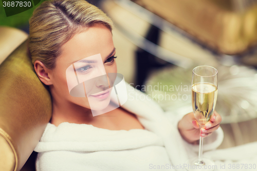 Image of beautiful young woman drinking champagne at spa