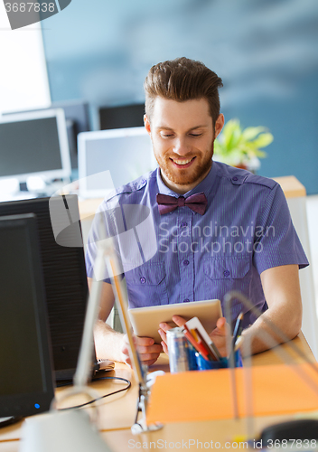 Image of happy creative male office worker with tablet pc