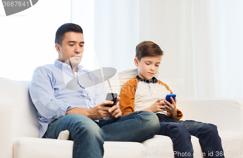 Image of father and son with smartphones at home