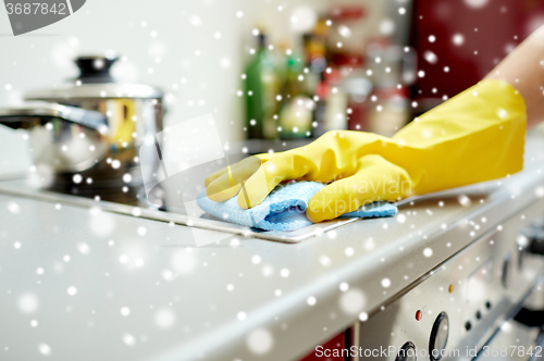 Image of close up of woman cleaning cooker at home kitchen