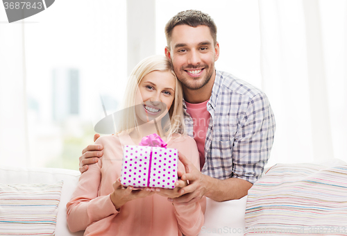 Image of happy man giving woman gift box at home