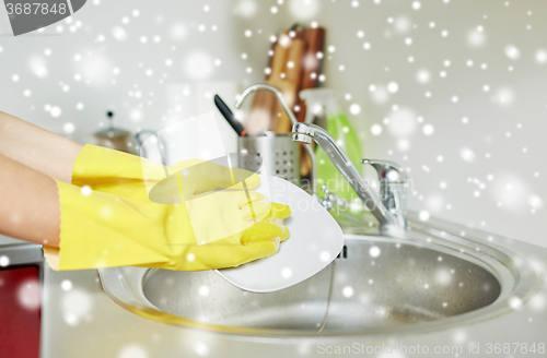 Image of close up of woman hands washing dishes in kitchen